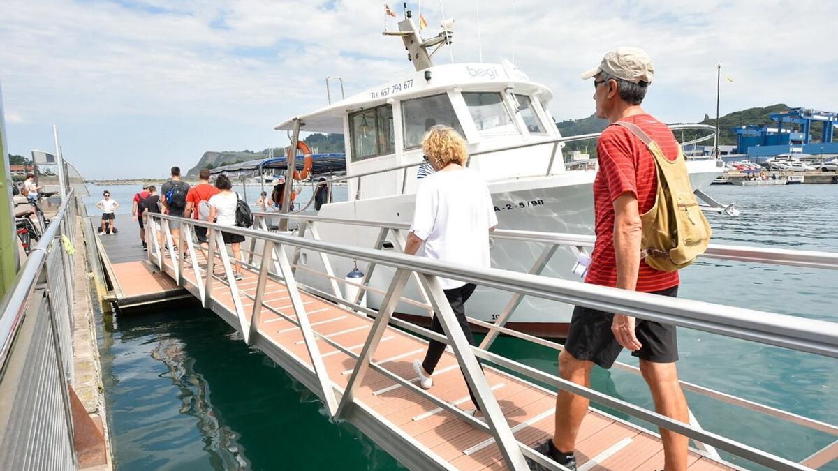 Un grupo de turistas de dispone a subir a un barco en Zumaia.