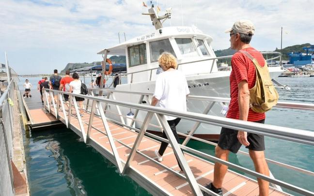 Un grupo de turistas de dispone a subir a un barco en Zumaia.