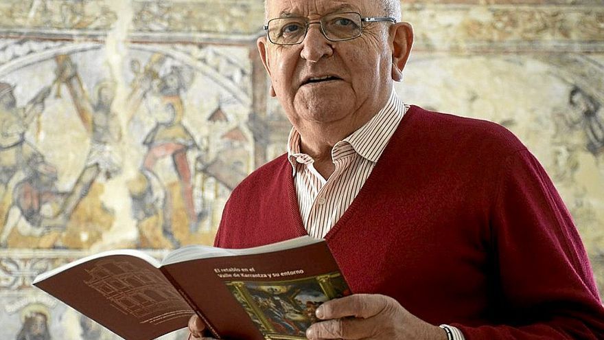 Eugenio Altazubiaga ense&ntilde;a su libro frente a las pinturas de San Andr&eacute;s de Bia&ntilde;ez. | FOTO: JOS&Eacute; MARI MART&Iacute;NEZ
