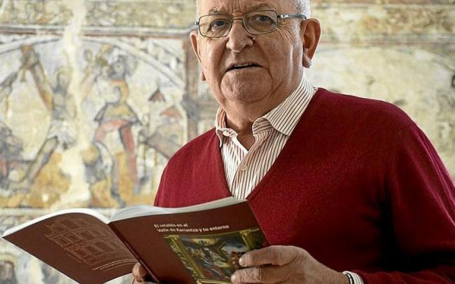 Eugenio Altazubiaga ense&ntilde;a su libro frente a las pinturas de San Andr&eacute;s de Bia&ntilde;ez. | FOTO: JOS&Eacute; MARI MART&Iacute;NEZ