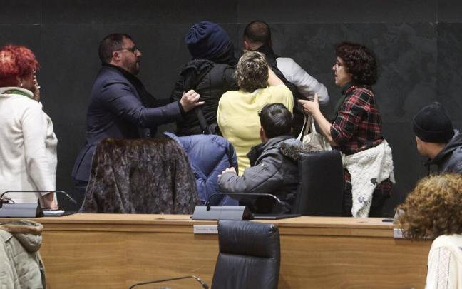 Unai Hualde, presidente del Parlamento foral, y Marisa de Simón, parlamentaria de I-E, tratan de socorrer al hombre que estaba siendo 'detenido' en el Parlamento. Unai Hualde, presidente del Parlamento foral, y Marisa de Simón, parlamentaria de I-E, tratan de socorrer al hombre que estaba siendo 'detenido' en el Parlamento.