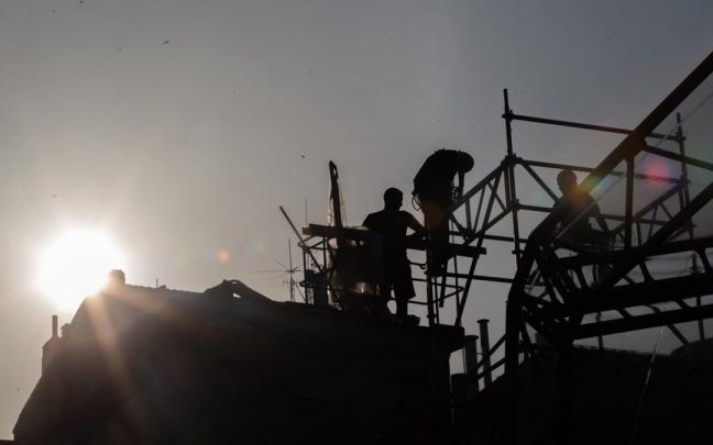 Operarios desmontan un escenario en medio del ambiente turbio por el humo.