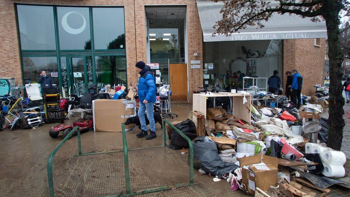 Varias personas ordenan material dañado en la calle Sancho Abarca (Rochapea) tras las inundaciones provocadas por el desbordamiento del río Arga.