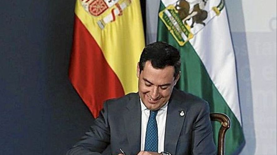 El presidente andaluz, Juan Manuel Moreno, firma con solemnidad el decreto de rebaja fiscal. | FOTO: E.P.