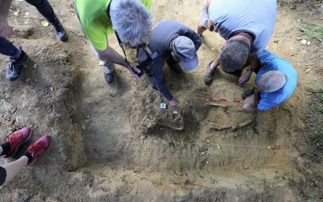 Trabajos de exhumaci&oacute;n de los restos de un gudari en una fosa de Mendata.