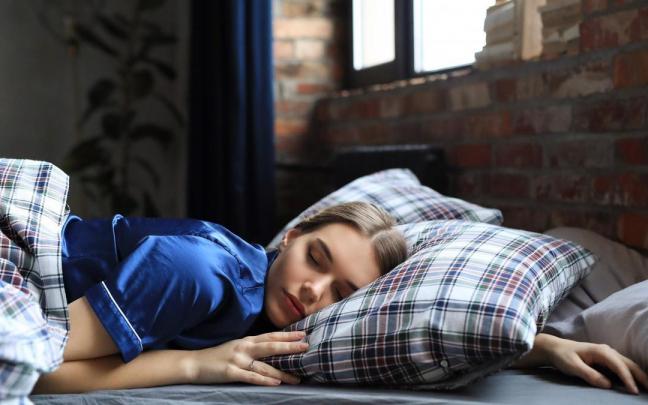 Una mujer duerme bien entrado el d&iacute;a.