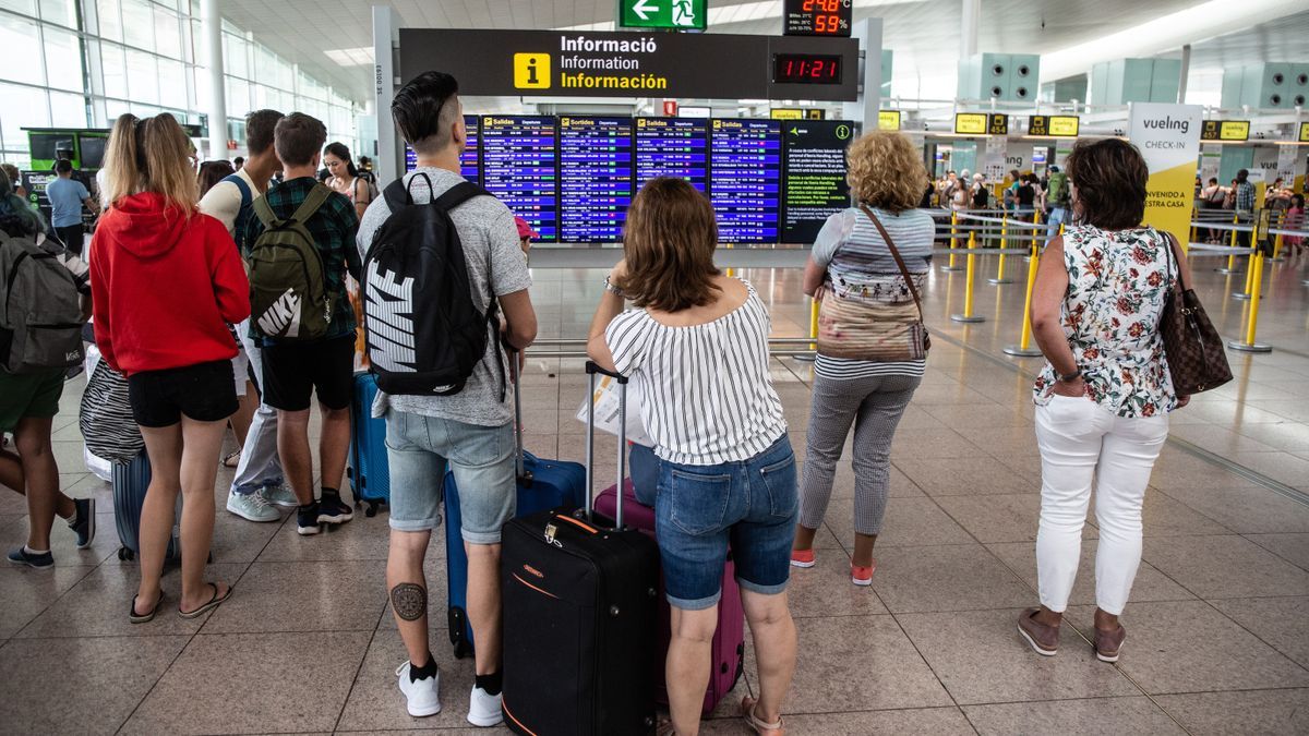 Varias personas esperan a embarcar en el aeropuerto de El Prat.