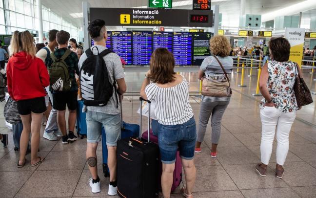 Varias personas esperan a embarcar en el aeropuerto de El Prat.