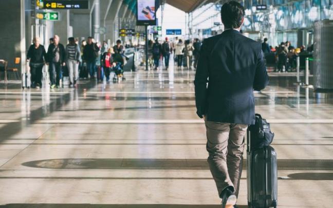 Un hombre con una maleta en un aeropuerto. Un hombre con una maleta en un aeropuerto.