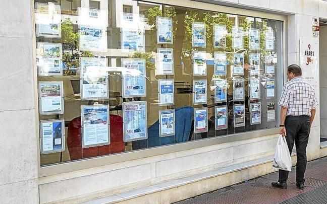 Un hombre mira los viajes disponibles para este verano en el escaparate de una agencia de la capital alavesa. Las vacaciones de sol y playa son las m&aacute;s demandadas.