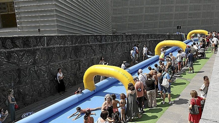 Los adultos se sitúan junto al gran tobogán hinchable para ver pasar a sus pequeños familiares.