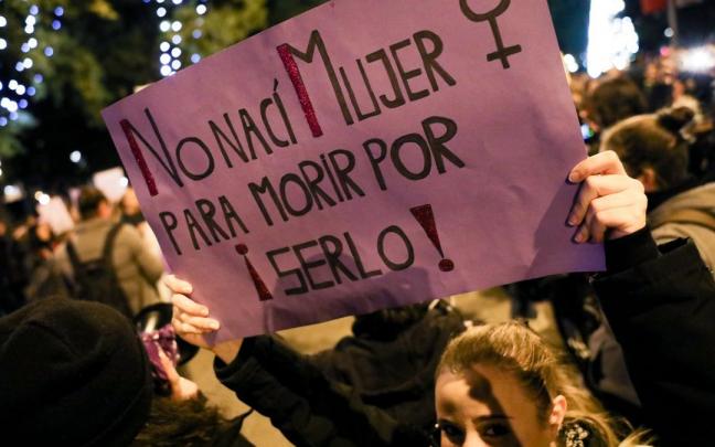 Una mujer ssotiene una pancarta en la que se lee 'No nac&iacute; mujer para morir por serlo'.
