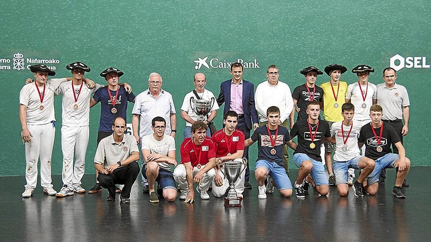 Los campeones, con txapela, y los finalistas posan con jueces y representantes de las instituciones, de la Federación Navarra de Pelota Vasca y de Caixabank, el patrocinador.