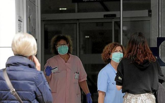 Una enfermera y una auxiliar atienden a varias personas en la entrada del ambulatorio de El Antiguo. Una enfermera y una auxiliar atienden a varias personas en la entrada del ambulatorio de El Antiguo.