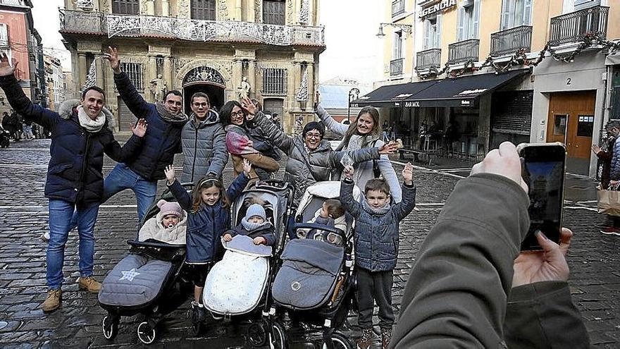 Un grupo de padres y madres posa con sus hijos, algunos en silleta, en la Plaza Consistorial.