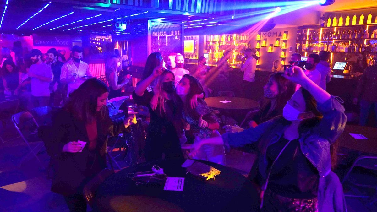 Varias jóvenes bailan en una discoteca.
