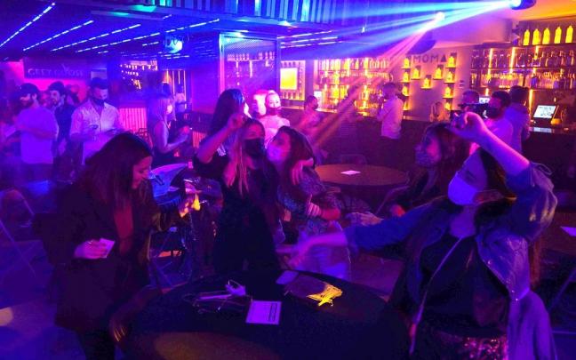 Varias jóvenes bailan en una discoteca. Varias jóvenes bailan en una discoteca.