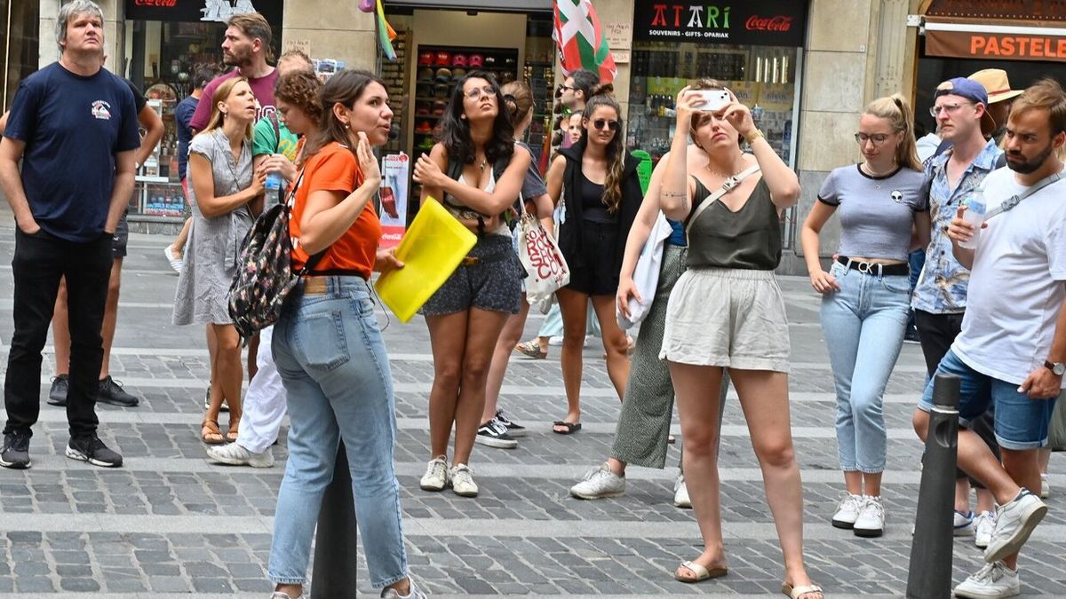 Un grupo de visitantes atendiendo a las explicaciones de una gu&iacute;a tur&iacute;stica en Bilbao.