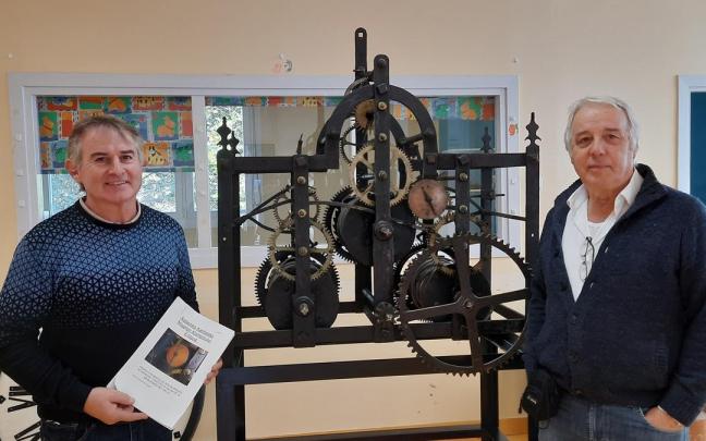 Agustín Lizarralde y Xabier Yeregi junto a la maquinaria del reloj que será restaurado. Agustín Lizarralde y Xabier Yeregi junto a la maquinaria del reloj que será restaurado.