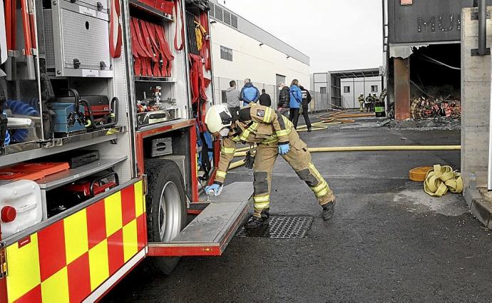 Bomberos trabajan en la extinción de un incendio en una nave en el polígono de Subillabide. Foto: Pilar Barco