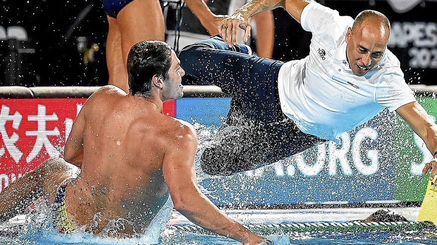 Alberto Munárriz, de espaldas, lanzándose a la piscina junto al seleccionador David Martín para celebrar el triunfo en el Campeonato del Mundo disputado en Budapest (Hungría). | FOTO: @RFEN