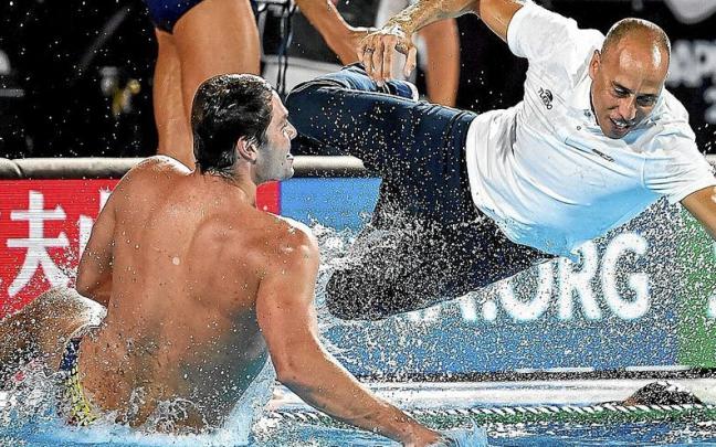 Alberto Munárriz, de espaldas, lanzándose a la piscina junto al seleccionador David Martín para celebrar el triunfo en el Campeonato del Mundo disputado en Budapest (Hungría). | FOTO: @RFEN