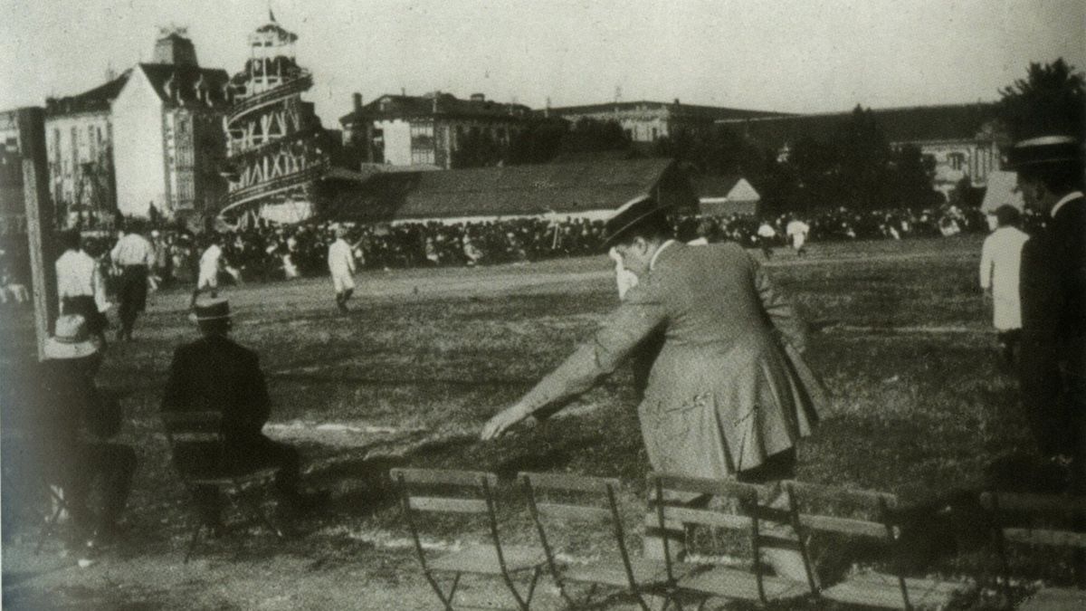 Al fondo, pegada al terreno de juego, se aprecia la atracci&oacute;n del tobog&aacute;n. Barracas y f&uacute;tbol en las fiestas de San Ferm&iacute;n de principios del siglo XX.