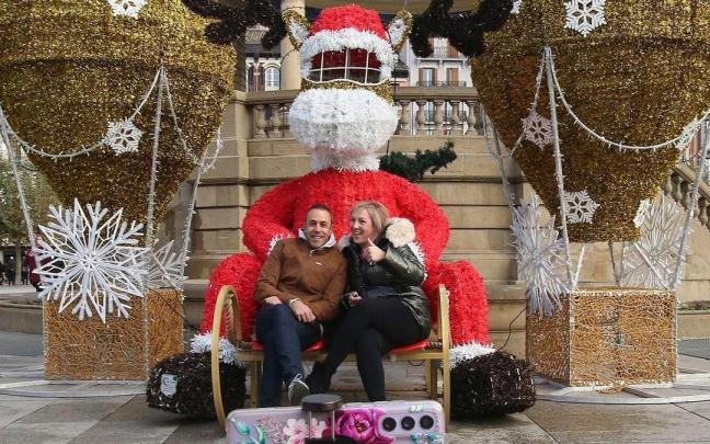 Una pareja posa sonriente en el reno navideño ubicado en la Plaza del Castillo. Una pareja posa sonriente en el reno navideño ubicado en la Plaza del Castillo.