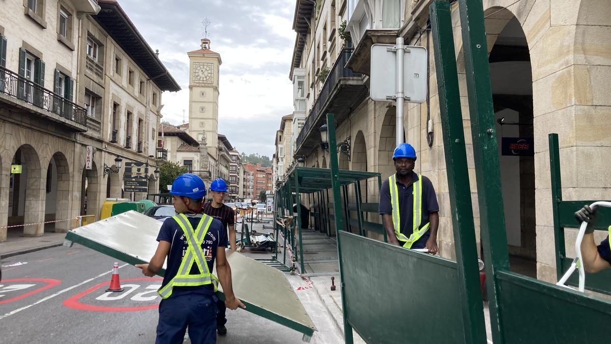 Varios operarios colocan los puestos del Último Lunes.