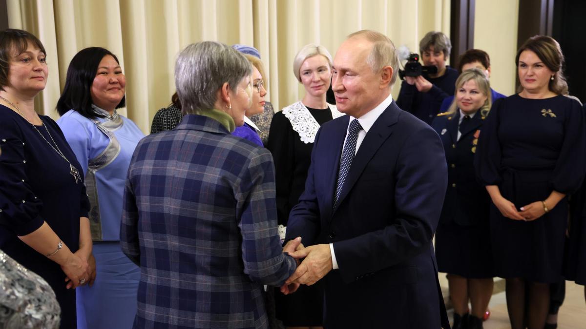 Vladimir Putin saluda a una de las mujeres.