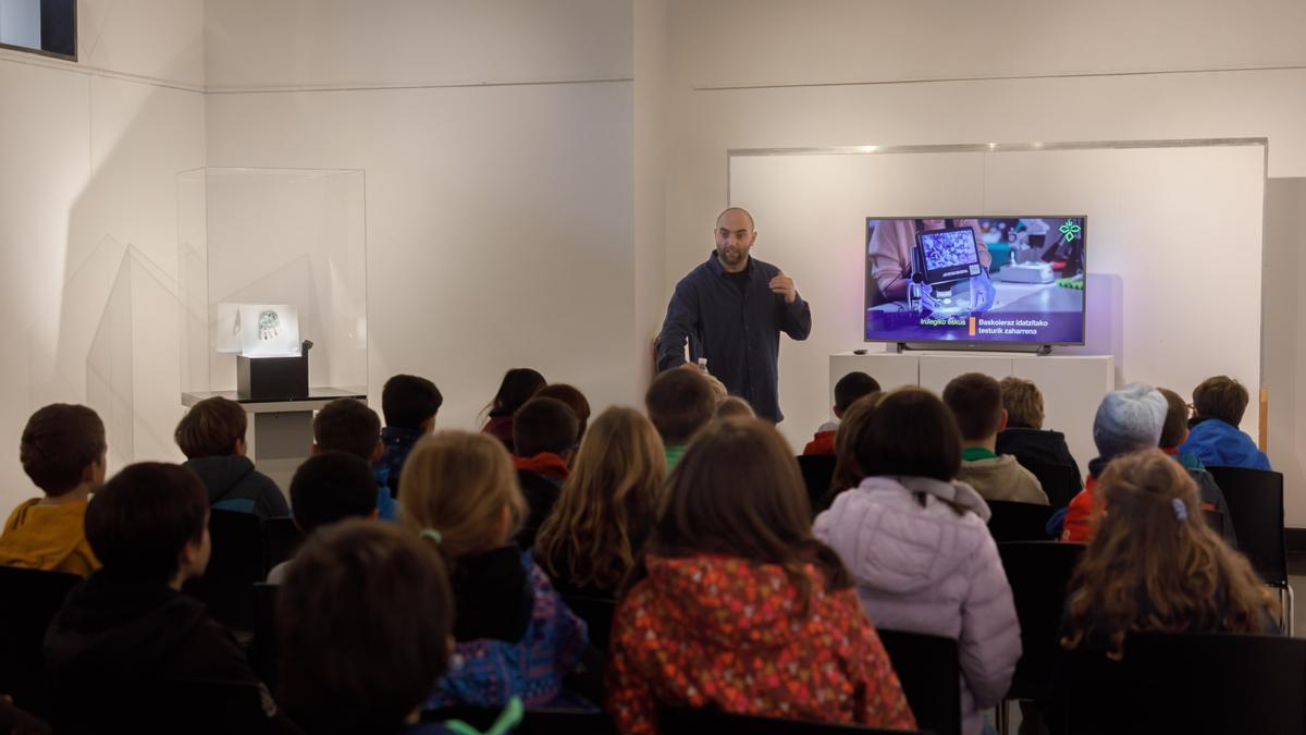Los escolares escuchan las explicaciones sobre la mano de Irulegi.