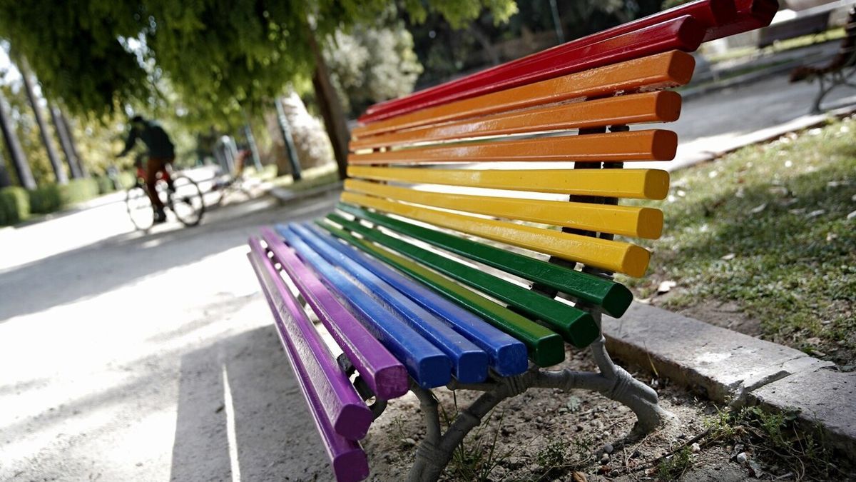 Un banco público decorado con los colores del arcoíris.