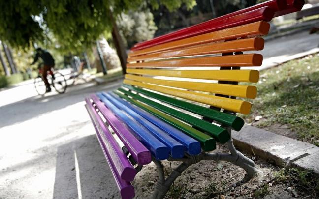 Un banco público decorado con los colores del arcoíris.