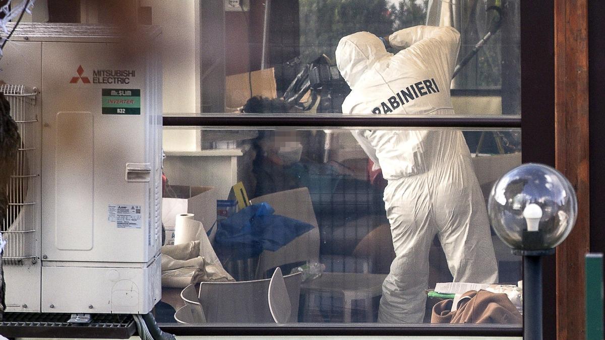 Un agente de la policía italiana examina el interior de la cafetería donde se produjo el tiroteo.