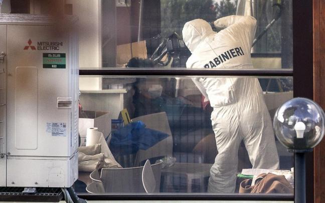 Un agente de la policía italiana examina el interior de la cafetería donde se produjo el tiroteo.