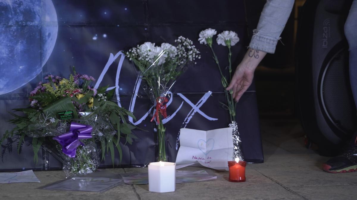 Una persona coloca flores durante una concentración-homenaje a Álex en el primer aniversario de su muerte