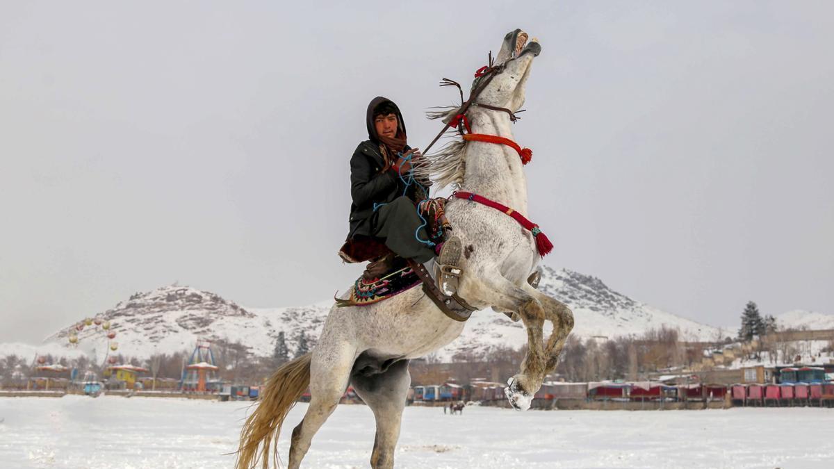 Un joven afgano monta a caballo en Kabul durante el temporal de frío y nieve.