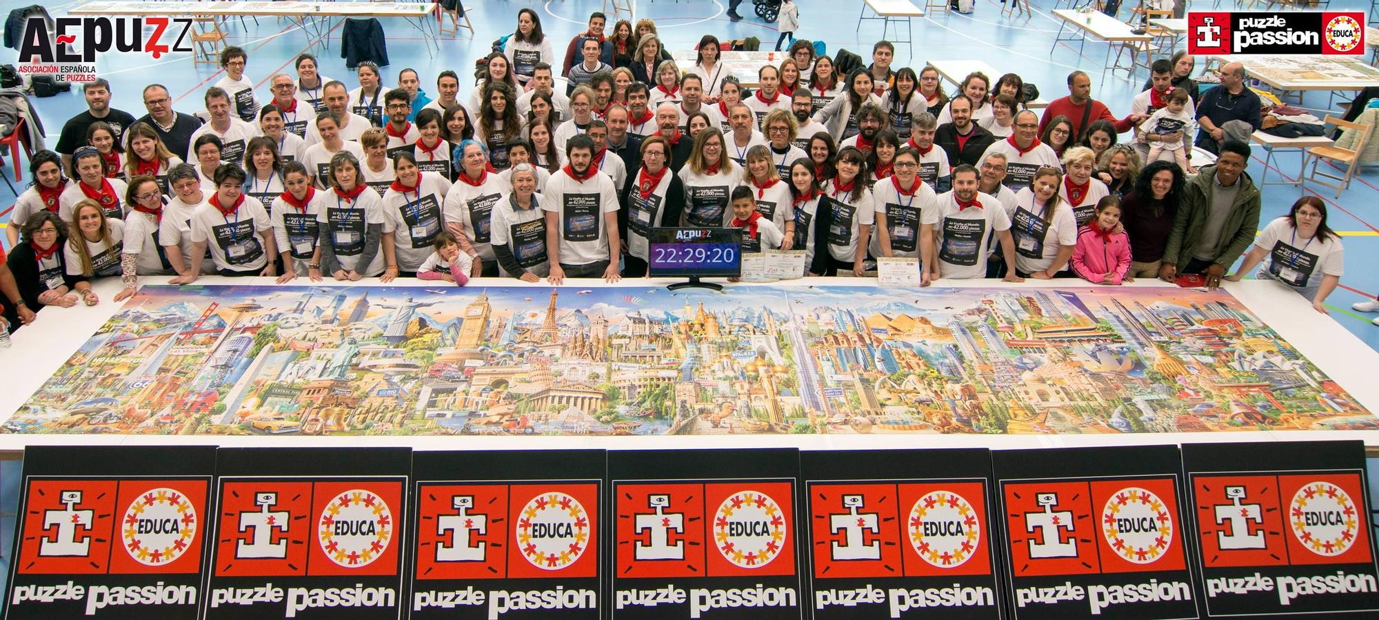 Foto de familia de la Asociación Española de Puzzles con los participantes en el reto, el puzzle montado y el cronómetro detenido en las 22 horas, 29 minutos y 20 segundos.