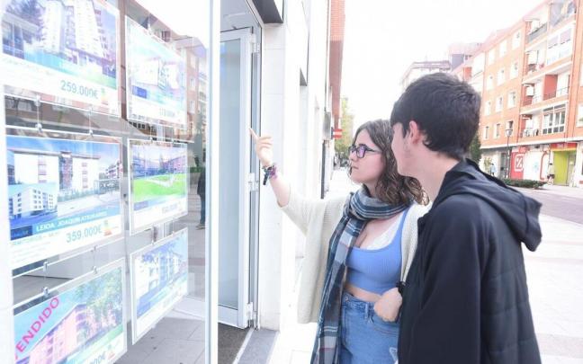 Dos jóvenes miran los anuncios de una inmobiliaria de Bilbao Dos jóvenes miran los anuncios de una inmobiliaria de Bilbao