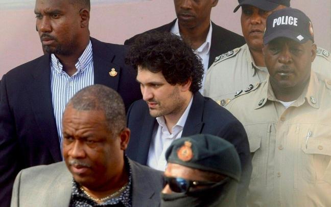 Sam Bankman-Fried (c) es escoltado por la policía de Bahamas. Sam Bankman-Fried (c) es escoltado por la policía de Bahamas.