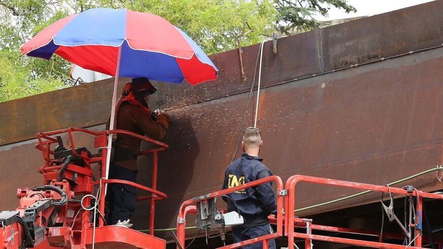 Trabajadores de la pasarela del labrit, bajo una sombrilla