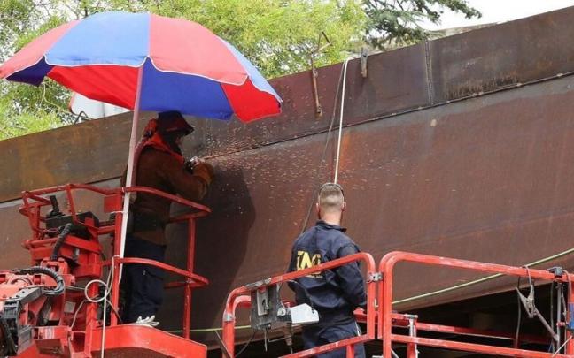 Trabajadores de la pasarela del labrit, bajo una sombrilla