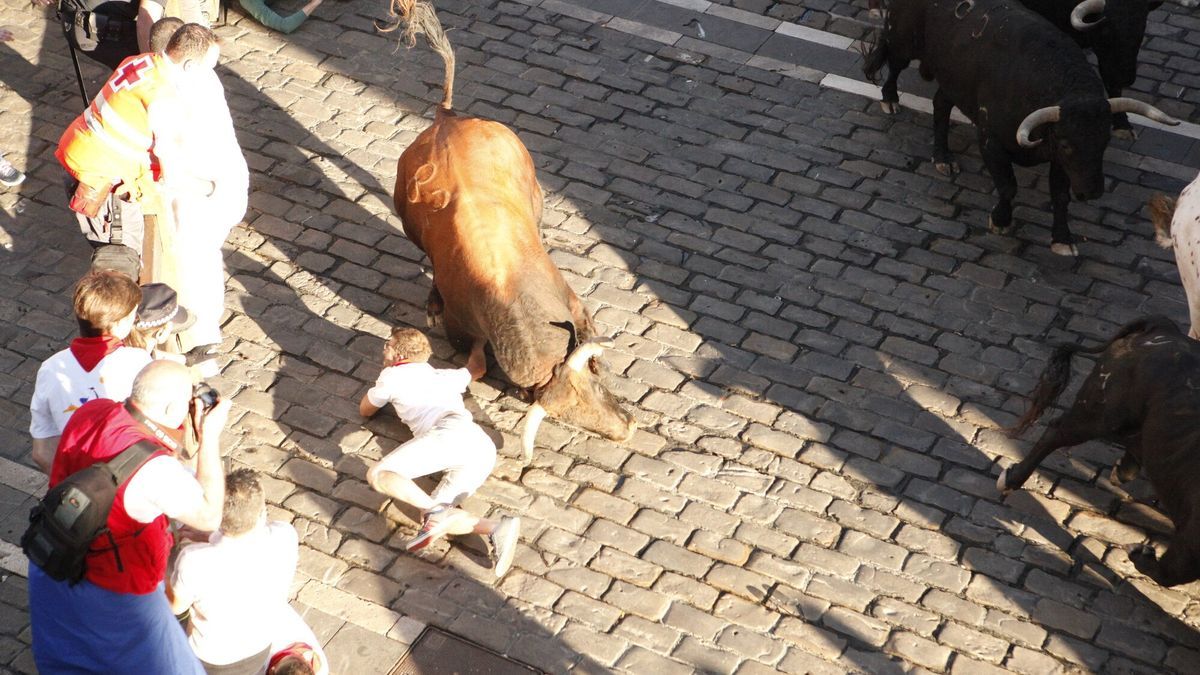 Un mozo cae al suelo ante las astas de un toro de Jandilla en el tramo del Ayuntamiento