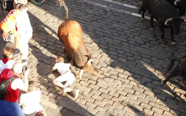 Un mozo cae al suelo ante las astas de un toro de Jandilla en el tramo del Ayuntamiento