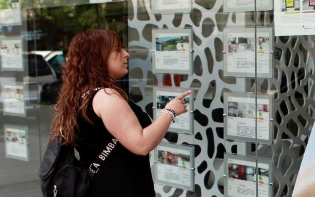 Una joven comprueba los precios de la vivienda en una inmobiliaria de Vitoria.