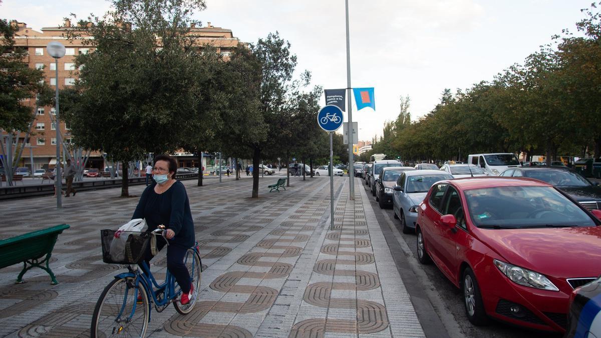 Ciclista circulando por el carril bici de la avenida Barañáin, en mal estado (sin pintura).