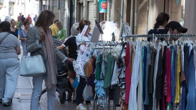 Varias personas observan prendas de ropa.