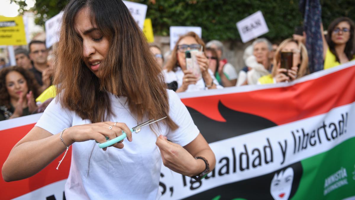 Una mujer se corta el pelo en una concentración contra la muerte de dos mujeres iraníes, frente a la embajada de Irán