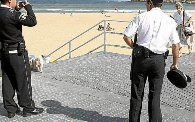 Un agente de la Guardia Municipal toma una fotografía en presencia de otro compañero de trabajo en la playa de la Zurriola. Un agente de la Guardia Municipal toma una fotografía en presencia de otro compañero de trabajo en la playa de la Zurriola.