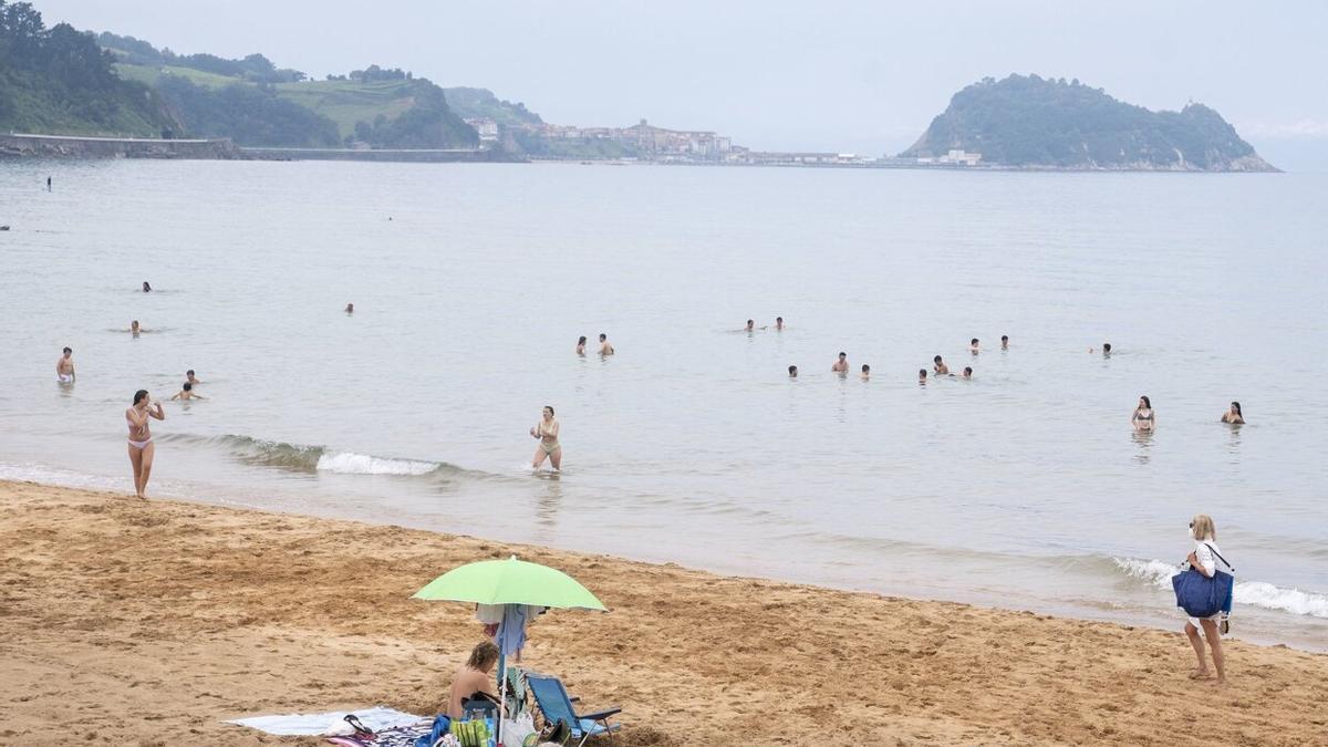 Varias personas se dan un baño en la playa de Zarautz